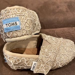 Tom’s adorable slip ons, gold and cream